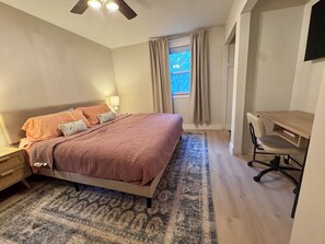 A bedroom with a bed, bedside table, lamp, desk, chair, and a window with curtains. - Family-Friendly Shore House 10 Minutes to Ocean City Beach Dog Friendly (Somers Point)