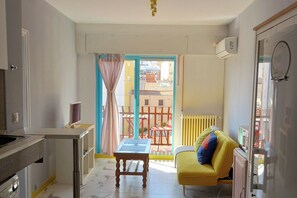A compact living space with a kitchen, a dining area, a sofa, and a balcony with a view of buildings. - Madrid Salamanca • Bright apartment with a terrace (Madrid)