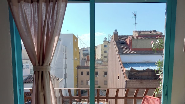 Un balcón con vistas a edificios cercanos y un cielo despejado.