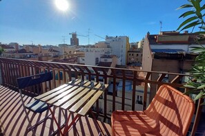 A balcony with a table and chairs, overlooking a cityscape with buildings and construction cranes. - Madrid Salamanca • Bright apartment with a terrace (Madrid)