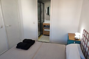 A hotel room with a bed, a bedside table with a lamp, a wardrobe, and a bathroom visible through an open door. - Madrid Salamanca • Bright apartment with a terrace (Madrid)