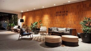 Eine moderne Lobby mit Holzwand, Sitzgelegenheiten und Topfpflanzen.