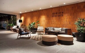 A modern lobby with a wooden wall, seating area, and potted plants. - Sunset Lovers Paradise w/ rooftop shared pool & jacuzzi w/ perfect location (Puerto Vallarta)