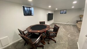 A conference room with a round table, six chairs, two windows with curtains, a flat-screen TV, and carpeted flooring. - Living on a budget? Look here! (Hays)