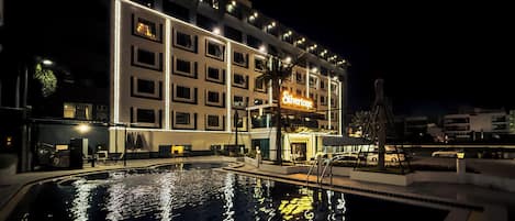 A hotel with a swimming pool, multiple floors, and a sign that reads 'Silverstone.'