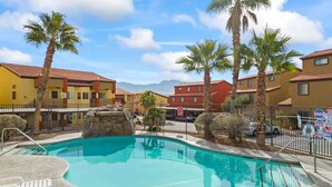 Una piscina circondata da palme e edifici colorati.