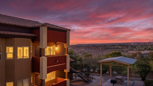 Un edificio a più piani con balconi, un patio coperto e vista su un paesaggio desertico.