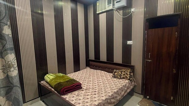Un dormitorio con cama, ventilador de techo y aire acondicionado.
