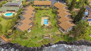 Ein Resort mit einem zentralen Pool, mehreren Gästezimmern und Blick auf den Ozean.