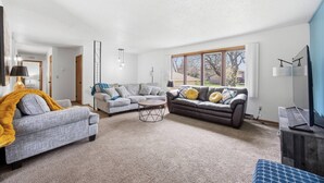 A spacious living room with a grey sofa, a brown leather sofa, and a coffee table. - Family-friendly duplex near Fargodome, kings+bunk (Fargo)