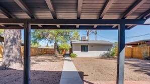 A covered patio area with a concrete path leading to a house. - Midtown Cozy Getaway! (Tucson)