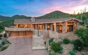 A modern house with a garage, a covered patio, and a driveway leading to the entrance. - Exquisite Starr Pass Desert Haven with Pool (Tucson)