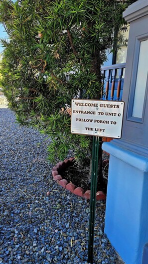 A sign welcoming guests to Unit C, directing them to follow the porch to the left. - Historic Studio near 4th Ave and U of A (Tucson)