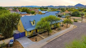 A residential area with houses, a paved road, and a mountain in the background. - Walkable Barrio Charm (Tucson)