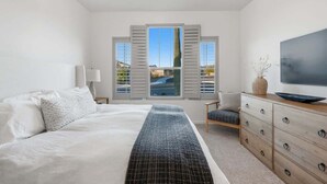 A bedroom with a bed, a TV, a dresser, and a window with shutters. - Exceptional Desert Escape w/ Pool and Spa (Marana)
