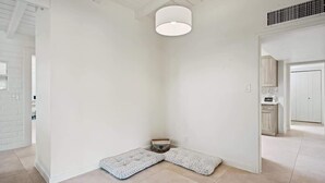 Een hoek van een kamer met een witte vloer, een witte muur en een witte deur.