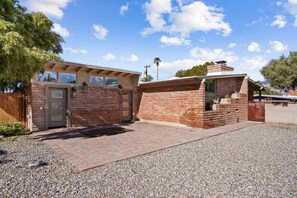 A two-story building with a brick facade, a covered patio area, and a gravel driveway. - Spacious Family Getaway-Pet Friendly! (Tucson)