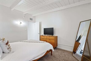 A bedroom with a bed, a dresser, a television, and a mirror. - Spacious Family Getaway-Pet Friendly! (Tucson)
