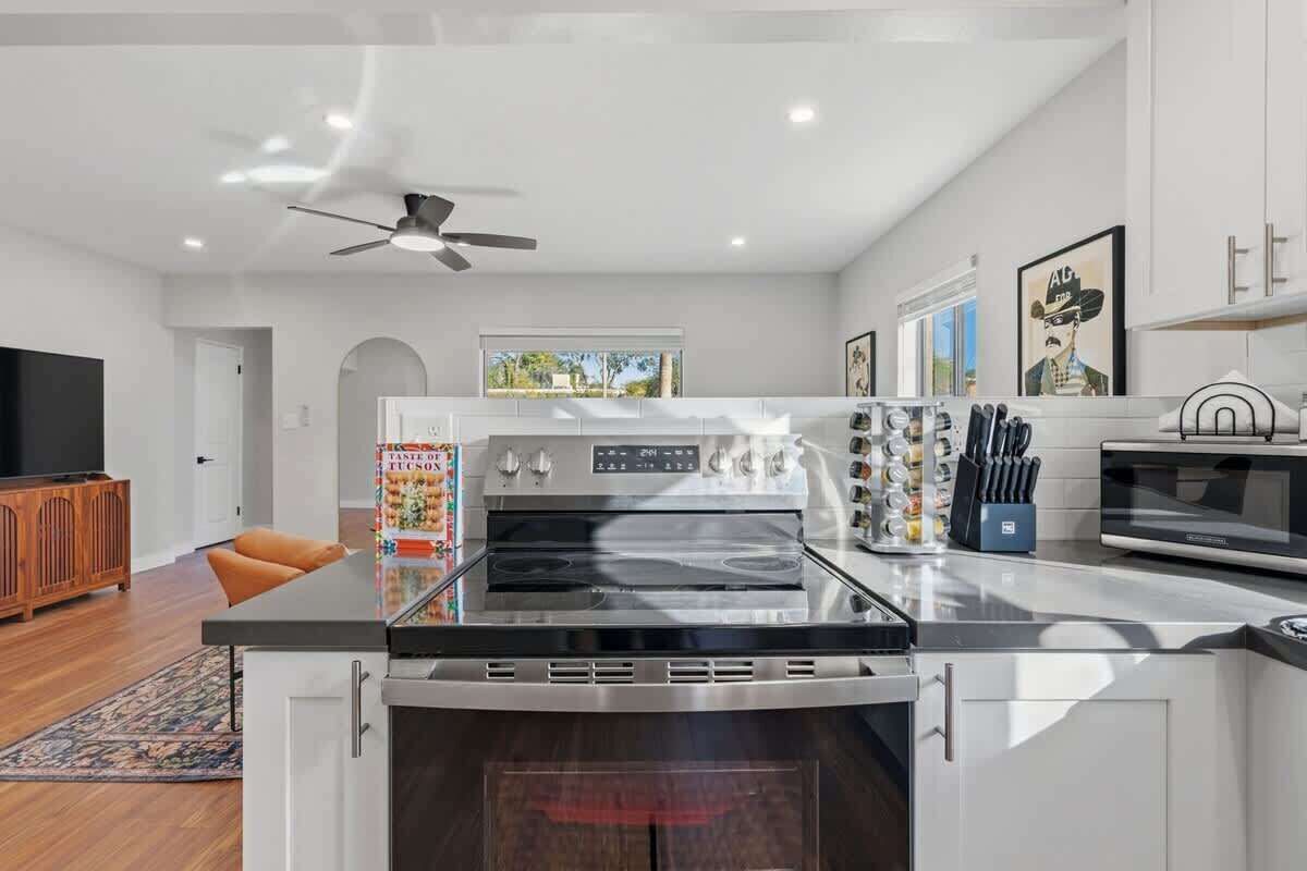 A modern kitchen with a built-in oven, a microwave, and a stovetop.