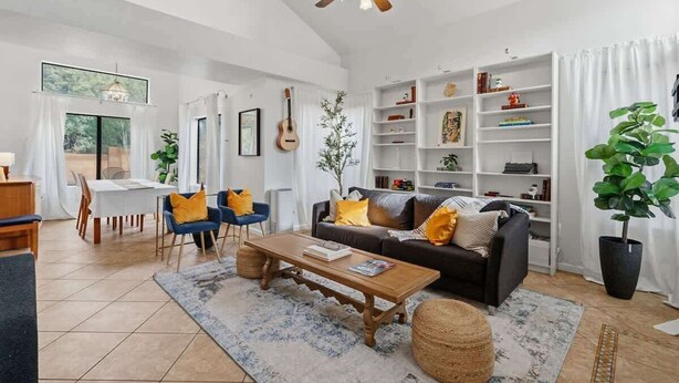 A living room with a sofa, coffee table, and bookshelves. - Bright & Spacious Family Retreat (Tucson)