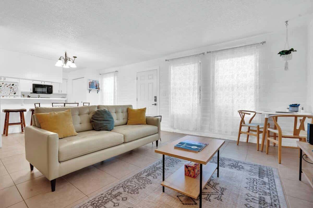Een moderne woonkamer met een bank, salontafel en eethoek.