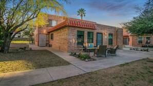 A brick house with a patio, outdoor seating, and a palm tree. - Cute Townhome with Community Pool 5 mins to TMC (Tucson)