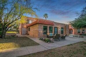 A brick house with a patio, outdoor seating, and a palm tree. - Cute Townhome with Community Pool 5 mins to TMC (Tucson)
