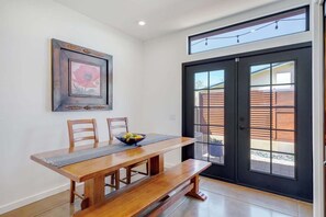 A dining area with a wooden table, two chairs, a bench, and a framed picture on the wall. - Pet Friendly-Walk to 4th Ave & Downtown! (Tucson)