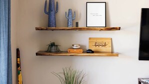 Two wooden shelves with decorative items, a framed quote, and a wooden sign. - Gated Desert Oasis w/ Pool (Marana)