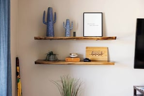 Two wooden shelves with decorative items, a framed quote, and a wooden sign. - Gated Desert Oasis w/ Pool (Marana)