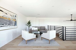A modern living room with a sofa, two armchairs, a coffee table, and a painting on the wall. - Foothills Upscale Retreat with Heated Pool (Tucson)