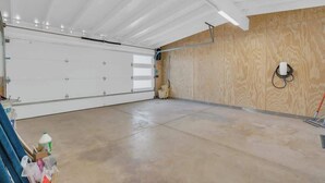 En garage med en hvid dør, trævægge og en beton gulv.