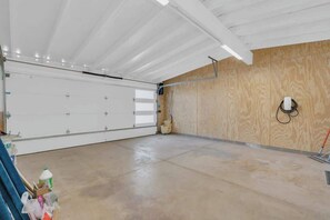 Eine Garage mit weißer Tür, Holzwänden und Betonboden.