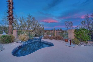 A swimming pool with a curved edge, surrounded by a brick wall and a metal fence. - Cactus & Sky Escape with POOL and SPA! (Tucson)
