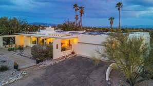 A modern house with a flat roof, large windows, and a driveway leading to the entrance. - Cactus & Sky Escape with POOL and SPA! (Tucson)