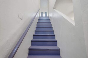 A staircase with a handrail, leading upwards in a narrow corridor. - Santa Rosa Hideaway near TCC (Tucson)