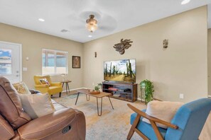 A living room with a sofa, armchairs, a coffee table, a TV, and a window with blinds. - Desert Escape- 5 Mins to Starr Pass & Hiking (Tucson)