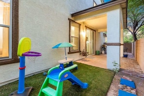 A backyard with a play area, a picnic table, and a covered seating area. - Peaceful 2 Story Home-Pet Friendly (Tucson)
