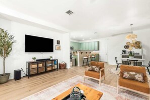 A modern living room with a flat-screen TV, a coffee table, and a sofa. - Peaceful 2 Story Home-Pet Friendly (Tucson)