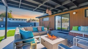 An outdoor patio with a fire pit, seating area, and a view of a swimming pool. - Mid-Century Desert Galore/Mt.Views/Pool (Tucson)