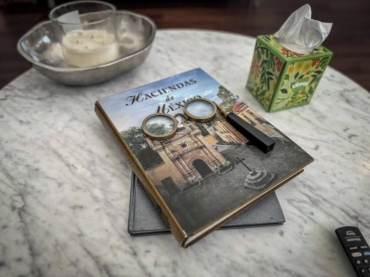 A book titled 'Fiacindas de Mexico' with a magnifying glass and a remote control on a marble surface.
