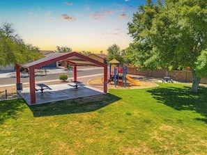 A covered outdoor area with a playground, picnic tables, and a well-maintained lawn. - Family Home-mins from the LOOP with Hot Tub! (Tucson)