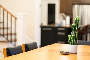 A dining table with a potted cactus and a metal plate. - Famous Historic Big Blue House (Tucson)