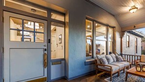 A front entrance with a door, a bench, and a rug. - Famous Historic Big Blue House (Tucson)