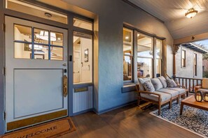 A front entrance with a door, a bench, and a rug. - Famous Historic Big Blue House (Tucson)