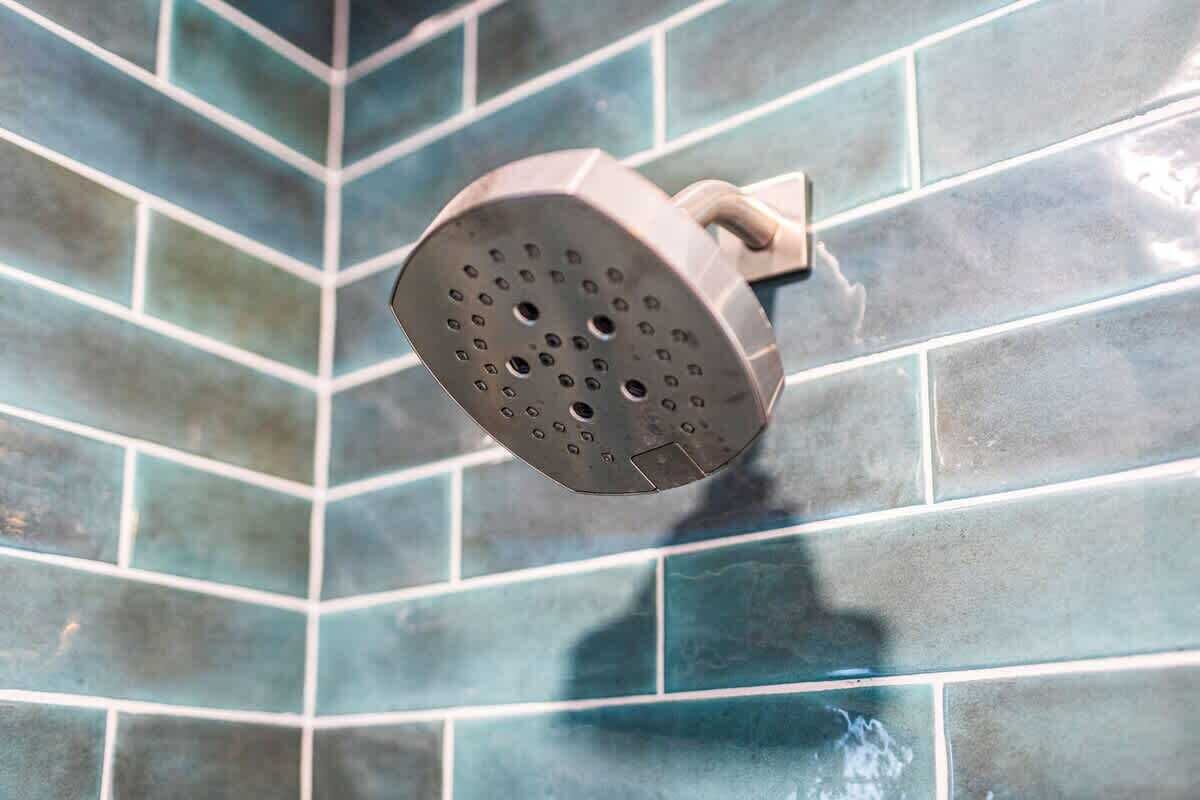 Un cabezal de ducha instalado en una pared de azulejos.