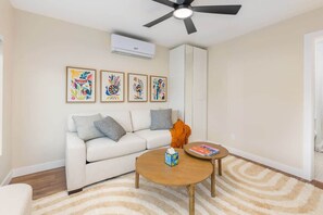 A living room with a white sofa, a round coffee table, and a ceiling fan. - Renovated Adobe with Hot Tub-Close to U of A (Tucson)