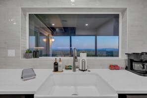 A modern kitchen with a large window, a sink, and a microwave. - Stunning View w/Heated Pool! (Tucson)