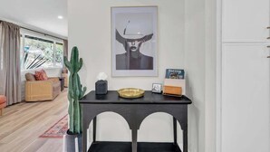 Una sala de estar moderna con un ventanal grande, un cactus, una obra de arte enmarcada y una mesita con una bandeja.