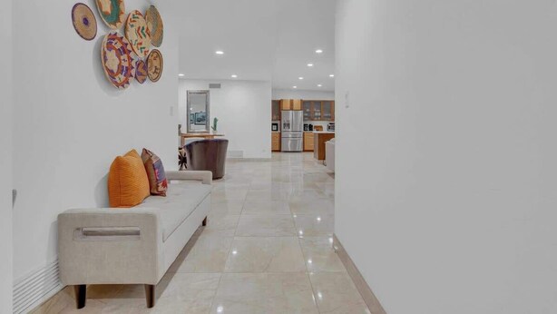 A modern interior with a sofa, pillows, and a wall-mounted decorative item. - Desert Vibes with Pool, Sauna & Game Room! (Tucson)